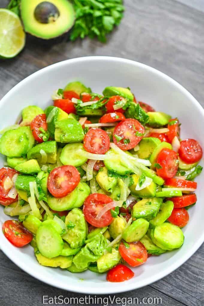 Simple Avocado Salad in a bowl with veggies on the background