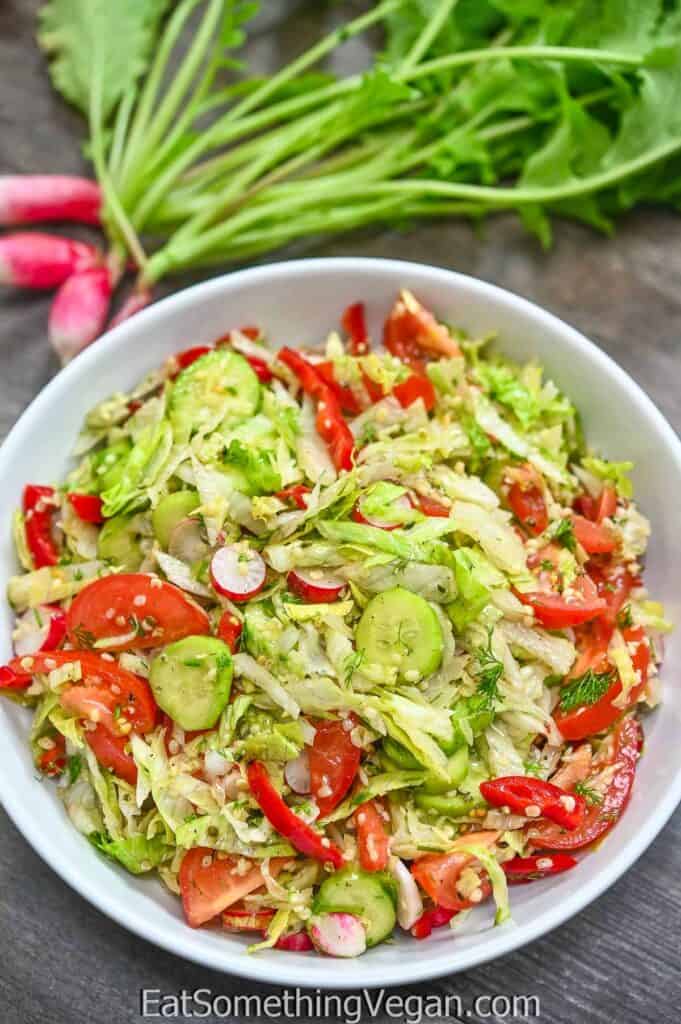 Iceberg Lettuce Salad in a bowl with radishes on the backgorund