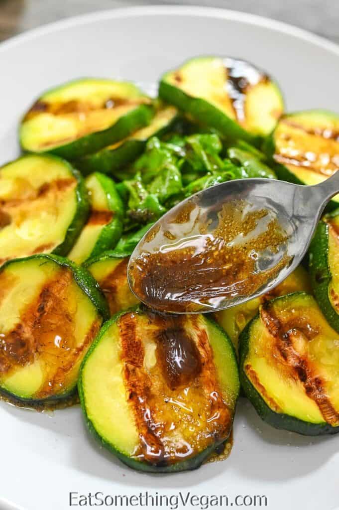 pouring balsamic dressing over grilled zucchini