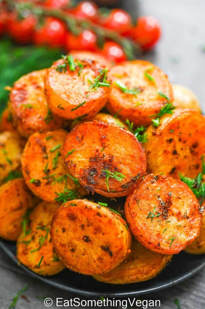 Baked Baby Potatoes on a plate with veggies on the background