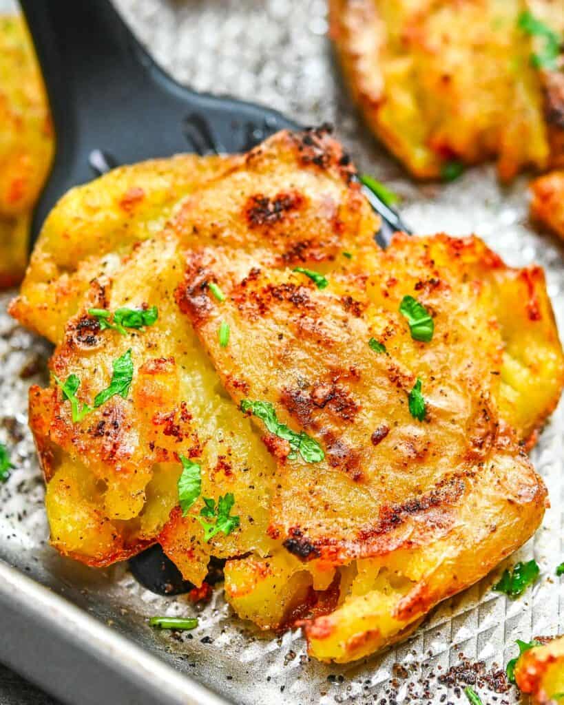 golden smashed potatoes on a baking sheet