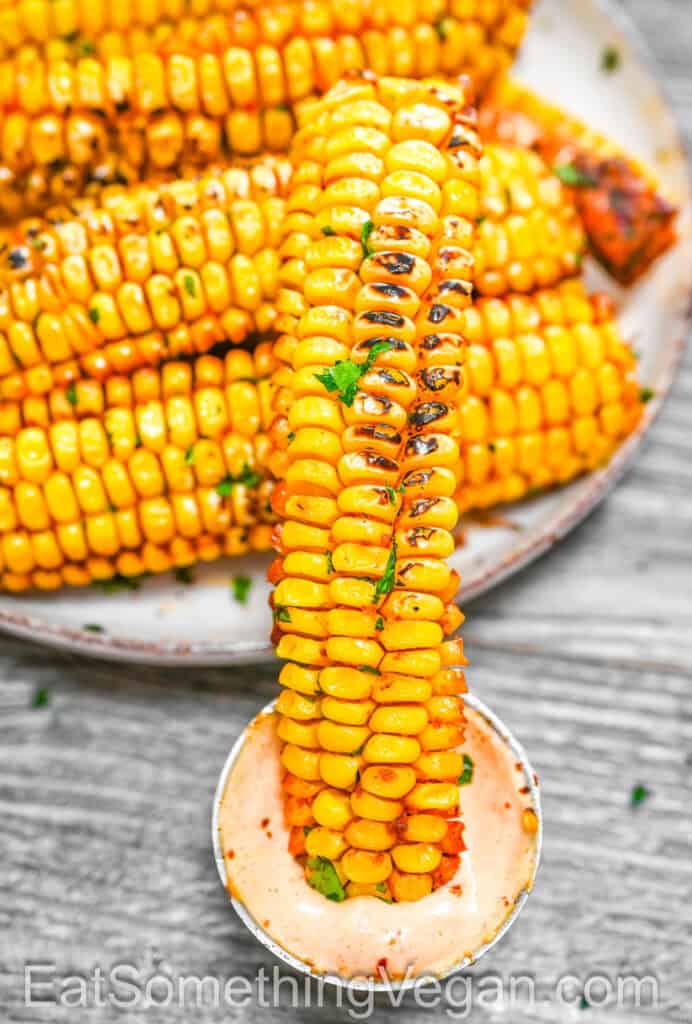 Close-up of a Corn Rib dipped in sauce