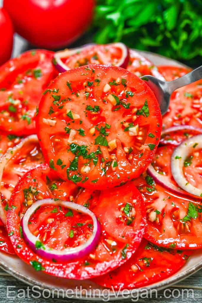 Marinated Tomatoes – a slice lifted with a fork