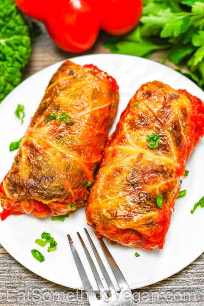 Vegan Cabbage Rolls served on a white plate with fresh herbs