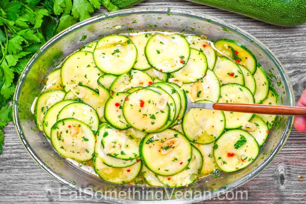 Marinated Zucchini in a container with herbs and garlic