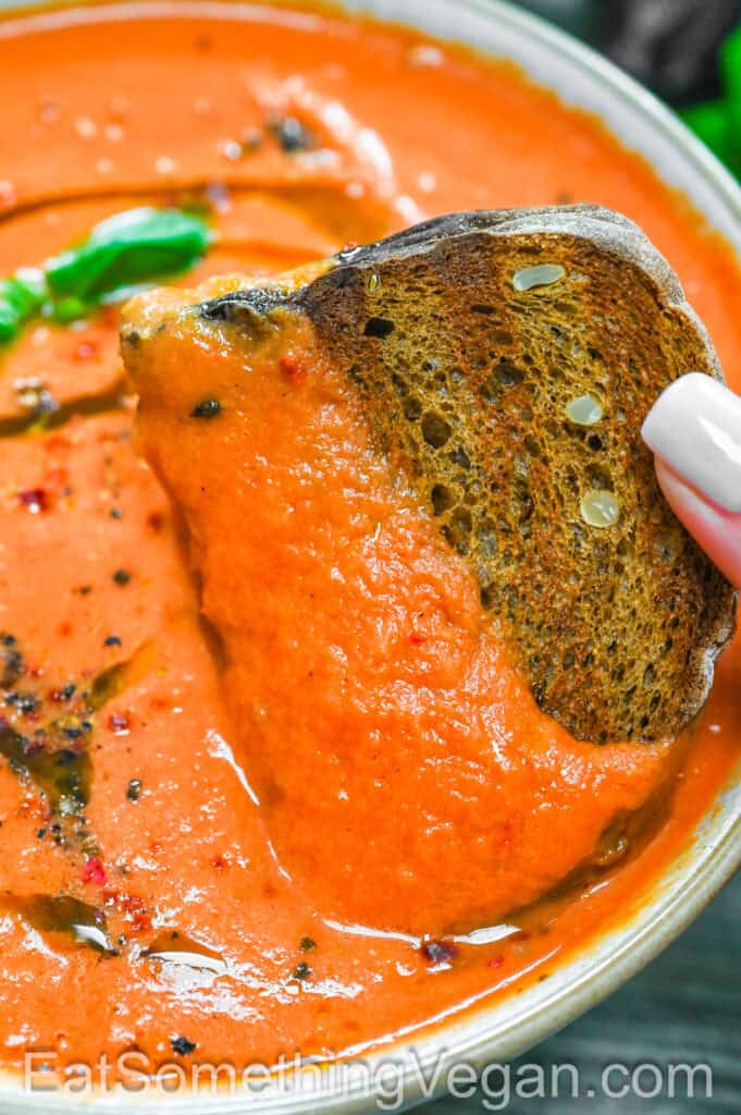 Roasted Tomato Soup with bread being dipped in