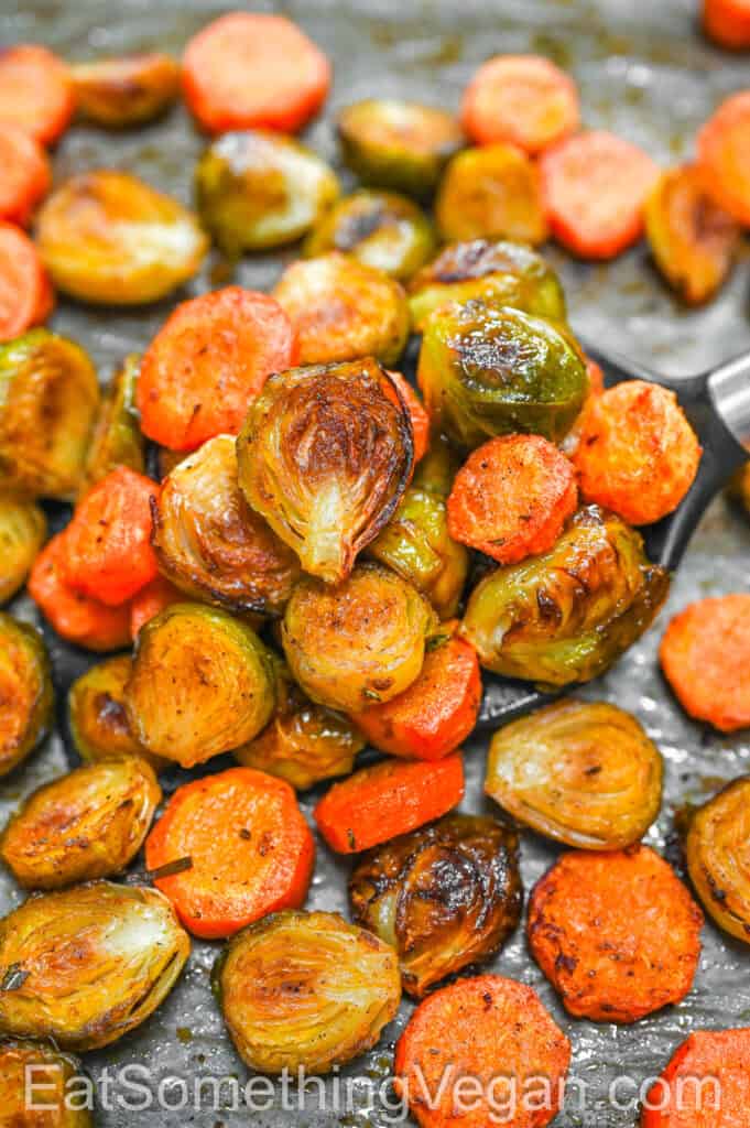 Baked Brussels Sprouts and Carrots on a spatula.