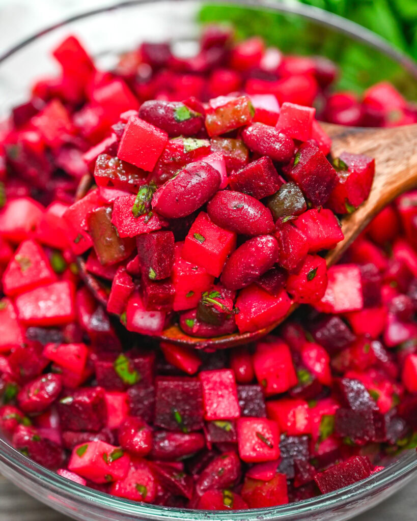 Colorful beet and bean salad with pickles and fresh herbs