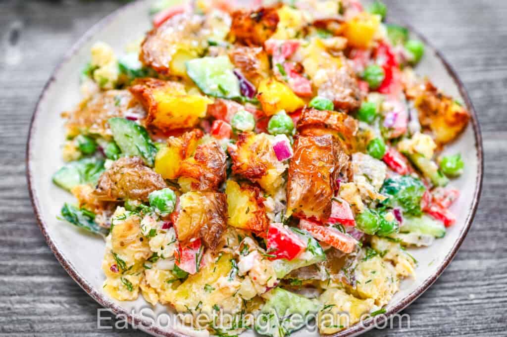 Creamy smashed potato salad served on a plate with crispy roasted potatoes