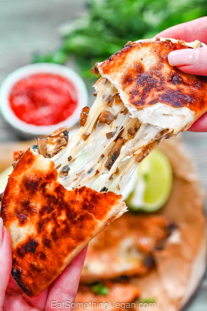 Crispy mushroom taco pulled apart with melted cheese stretching