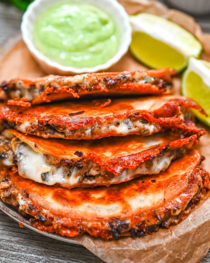 Crispy tacos with mushrooms, melted cheese, and green sauce