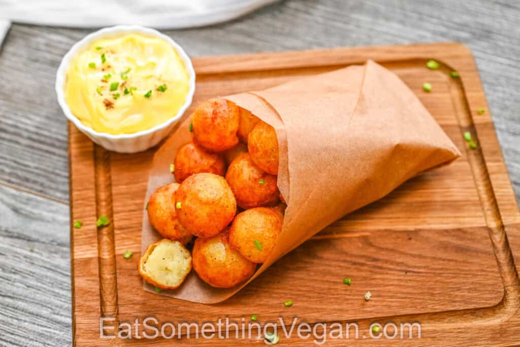 Crispy potato balls served in a paper cone with creamy dipping sauce