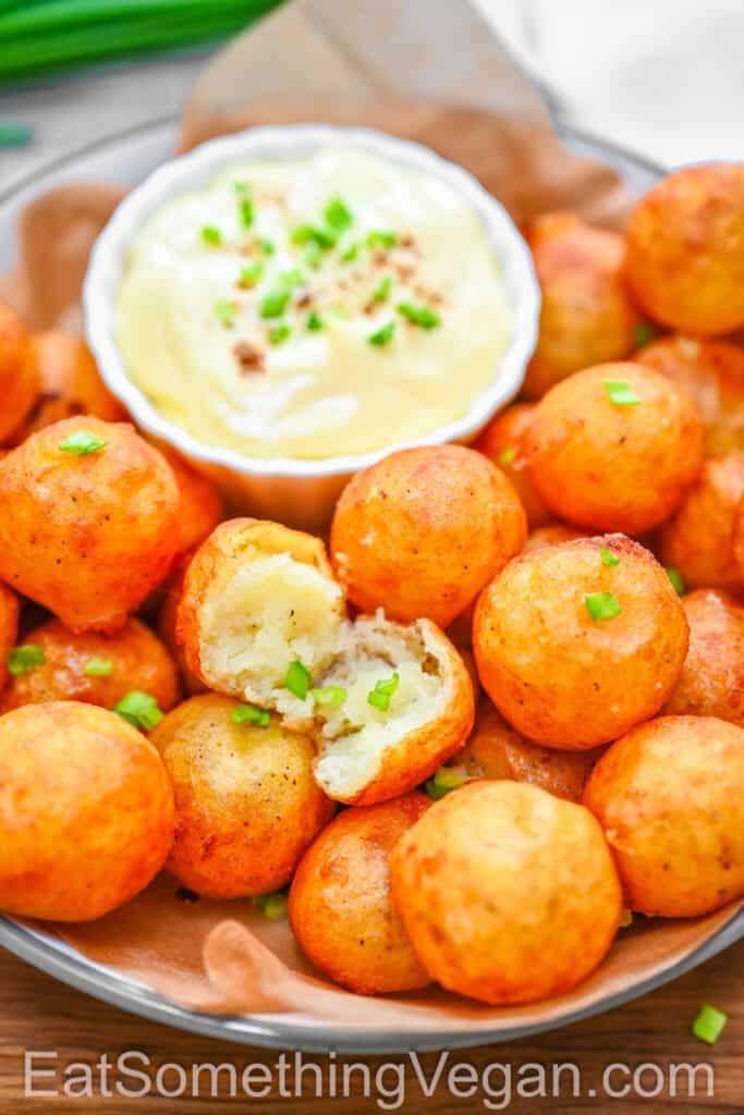 Close-up of crispy potato balls with creamy dipping sauce