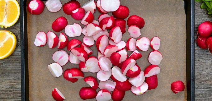 Cut radishes on a parchment-lined baking sheet.