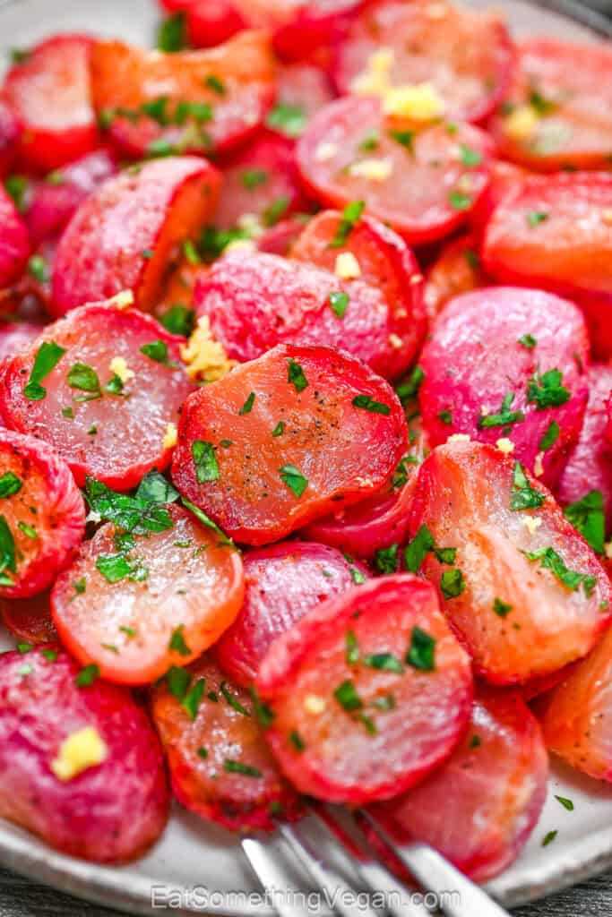 Close-up of roasted radishes with lemon zest and fresh parsley.