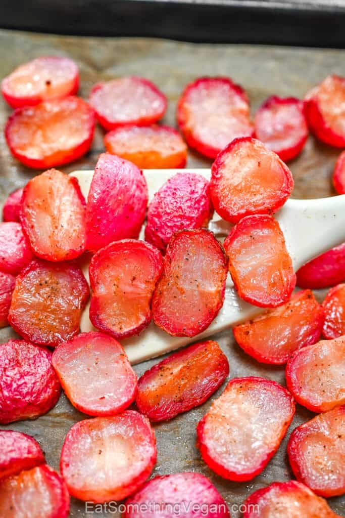 Roasted radishes on a parchment-lined baking sheet.