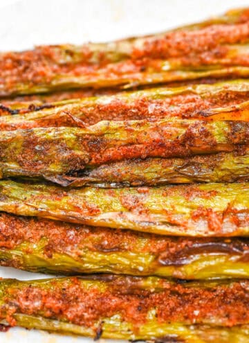 Close-up of crispy smashed asparagus with seasoning and nutritional yeast.