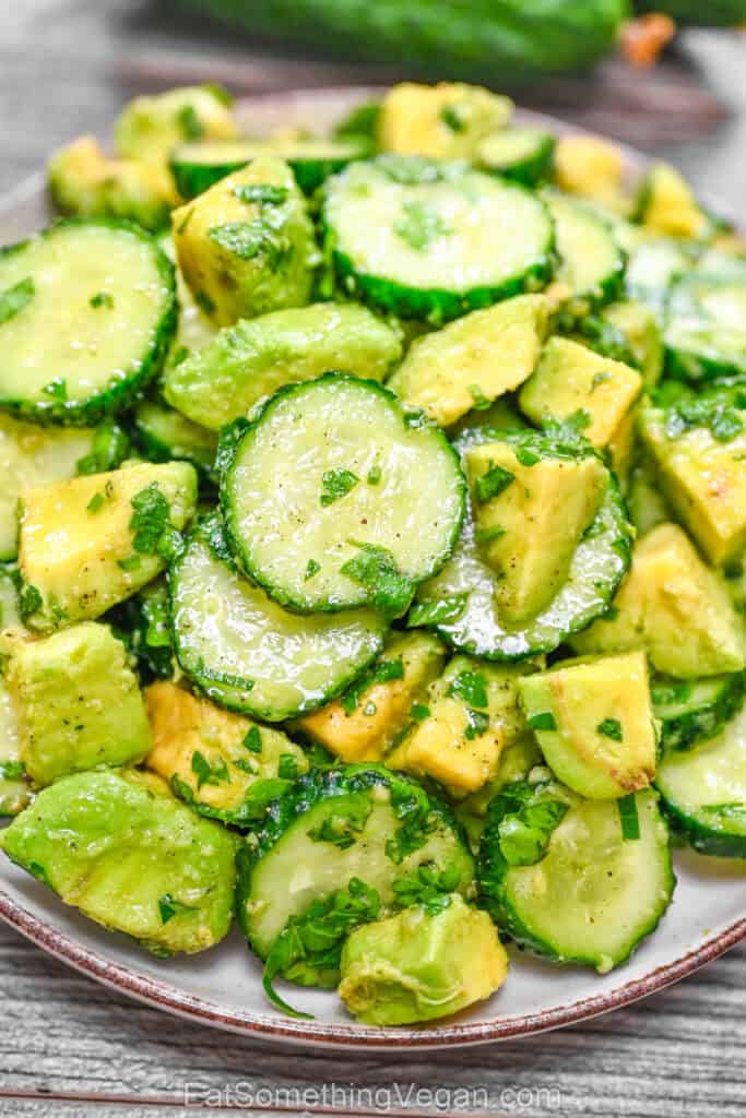 Fresh salad with cucumbers, avocado, and herbs in a bowl