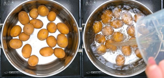 Boiling baby potatoes in a stainless steel pot filled with water.