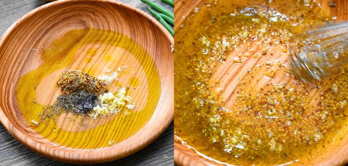 Whisking whole grain mustard, olive oil, lemon juice, and garlic in a wooden bowl to make salad dressing.