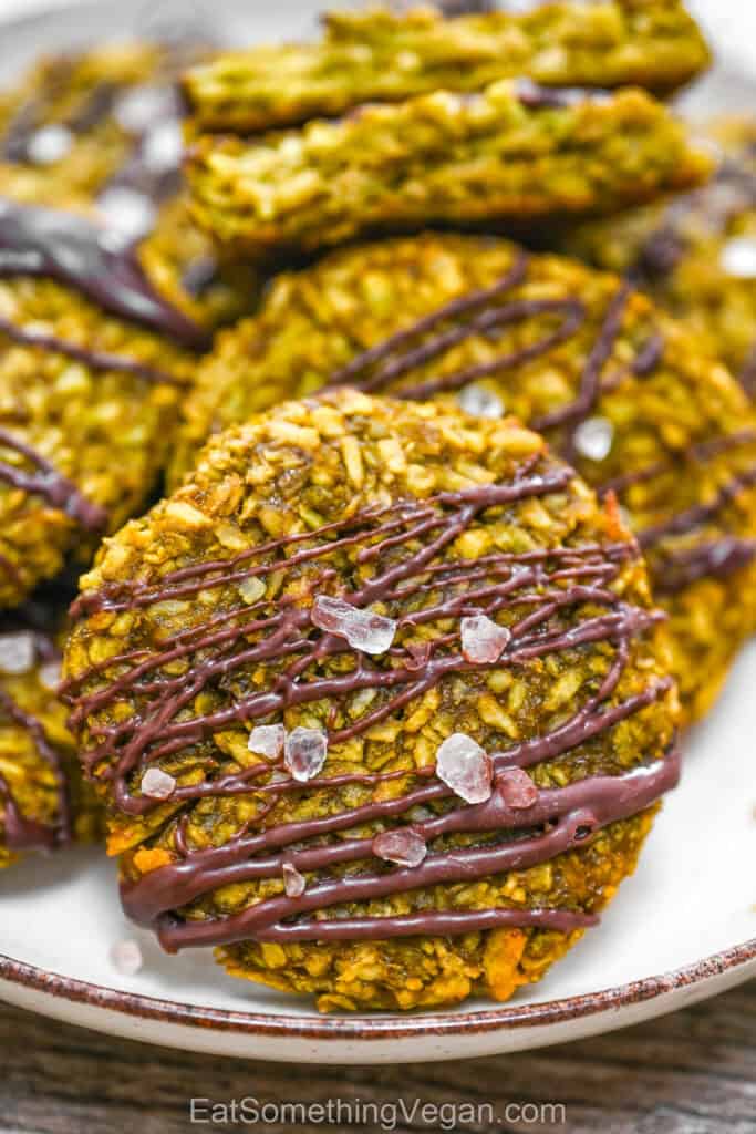 An easy homemade matcha coconut cookie with a chocolate drizzle and sea salt, showcasing a soft and chewy texture.