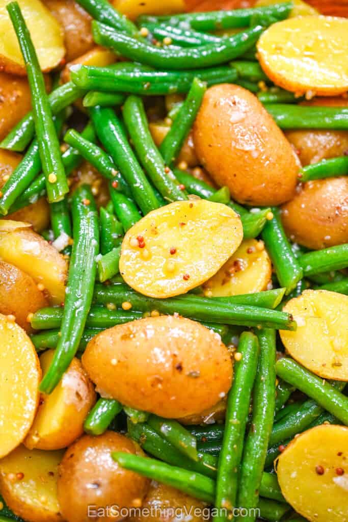 Warm Potato and Green Bean Salad texture shot, showcasing a detailed overhead view of the glossy mustard seed dressing coating the potatoes and fresh green beans.