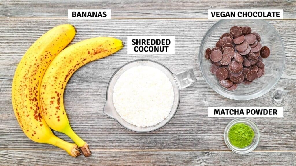 Ripe bananas, shredded coconut, vegan chocolate chips, and green matcha powder arranged on a wooden background with text labels for each ingredient.