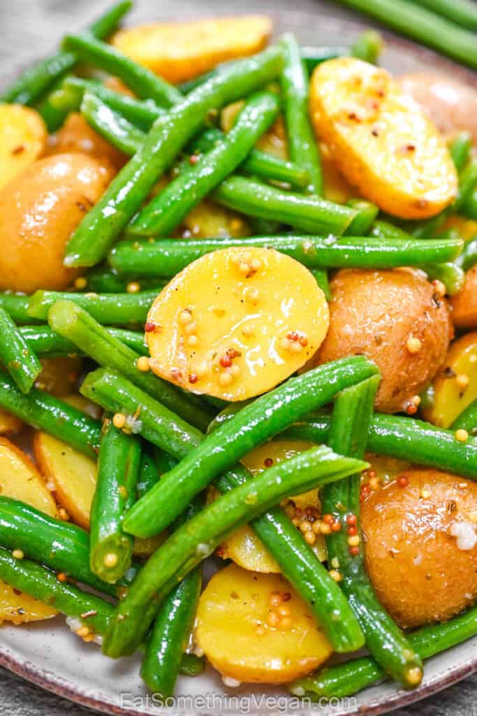 Warm Potato and Green Bean Salad served on a plate, close-up shot showing tender baby potatoes and crisp green beans in a mustard dressing.