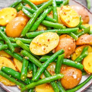 Warm Potato and Green Bean Salad close-up shot, showcasing tender baby potato halves and fresh green beans coated in a whole grain mustard dressing.