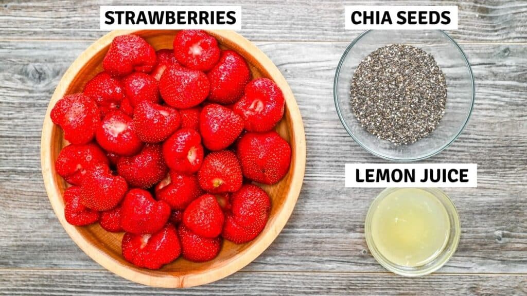 Flat lay of ingredients with labels: strawberries in a wooden bowl, chia seeds in a glass bowl, and lemon juice in a small dish.