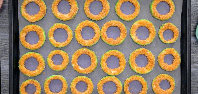Arranging seasoned zucchini rings on a baking sheet.