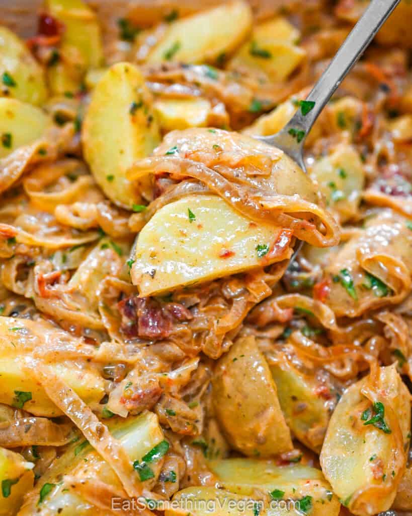 Caramelized onion potatoes on a spoon close up.