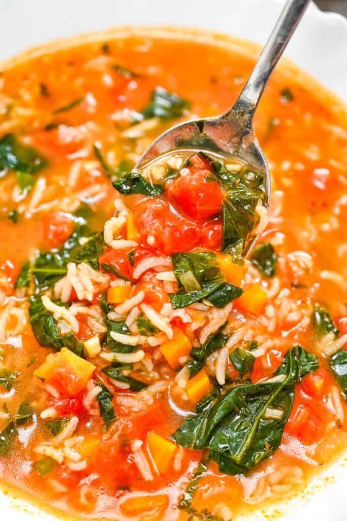 Tomato Spinach Rice Soup, close-up on a spoon.