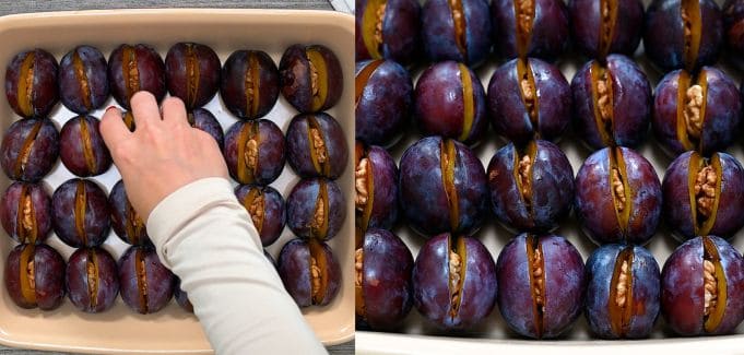 A hand neatly places a fresh, walnut-stuffed Italian plum into a ceramic baking dish filled with rows of closely packed plums, ready for roasting.
