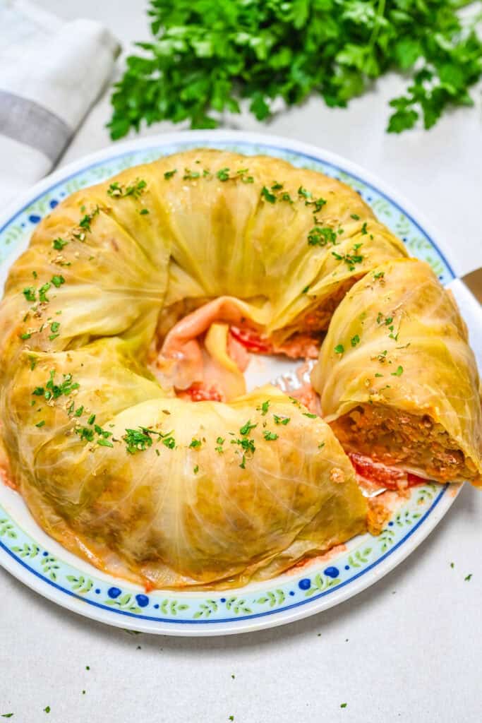 Sliced Bundt pan cabbage roll cake on a serving plate, showing the layered filling of rice, vegetables, and savory vegan meat inside