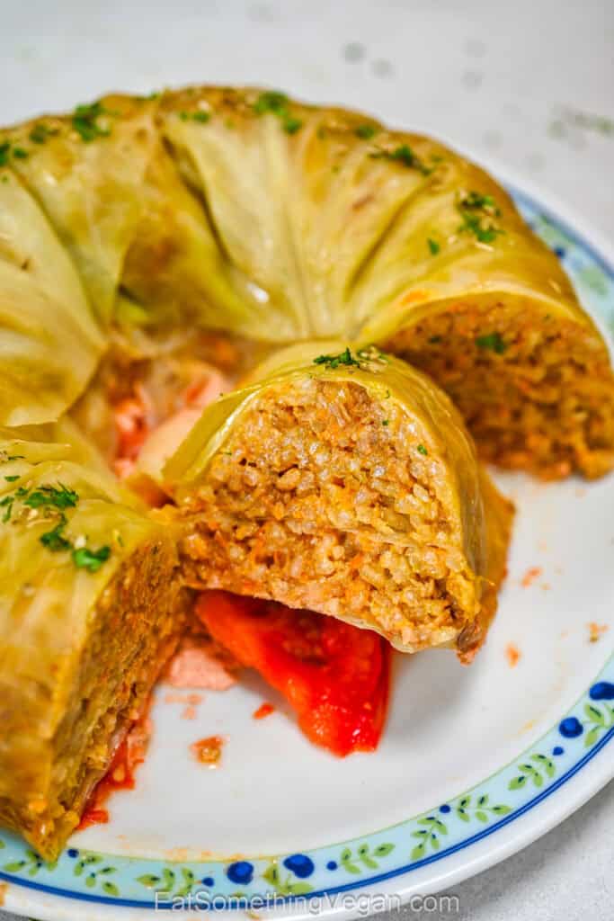 Close-up cross section of a sliced Bundt pan cabbage roll cake, displaying the hearty rice and plant-based meat filling with baked tomato base