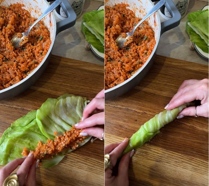 Spooning seasoned tomato rice filling onto a softened cabbage leaf and rolling it into a slender open-ended rope on a wooden board.